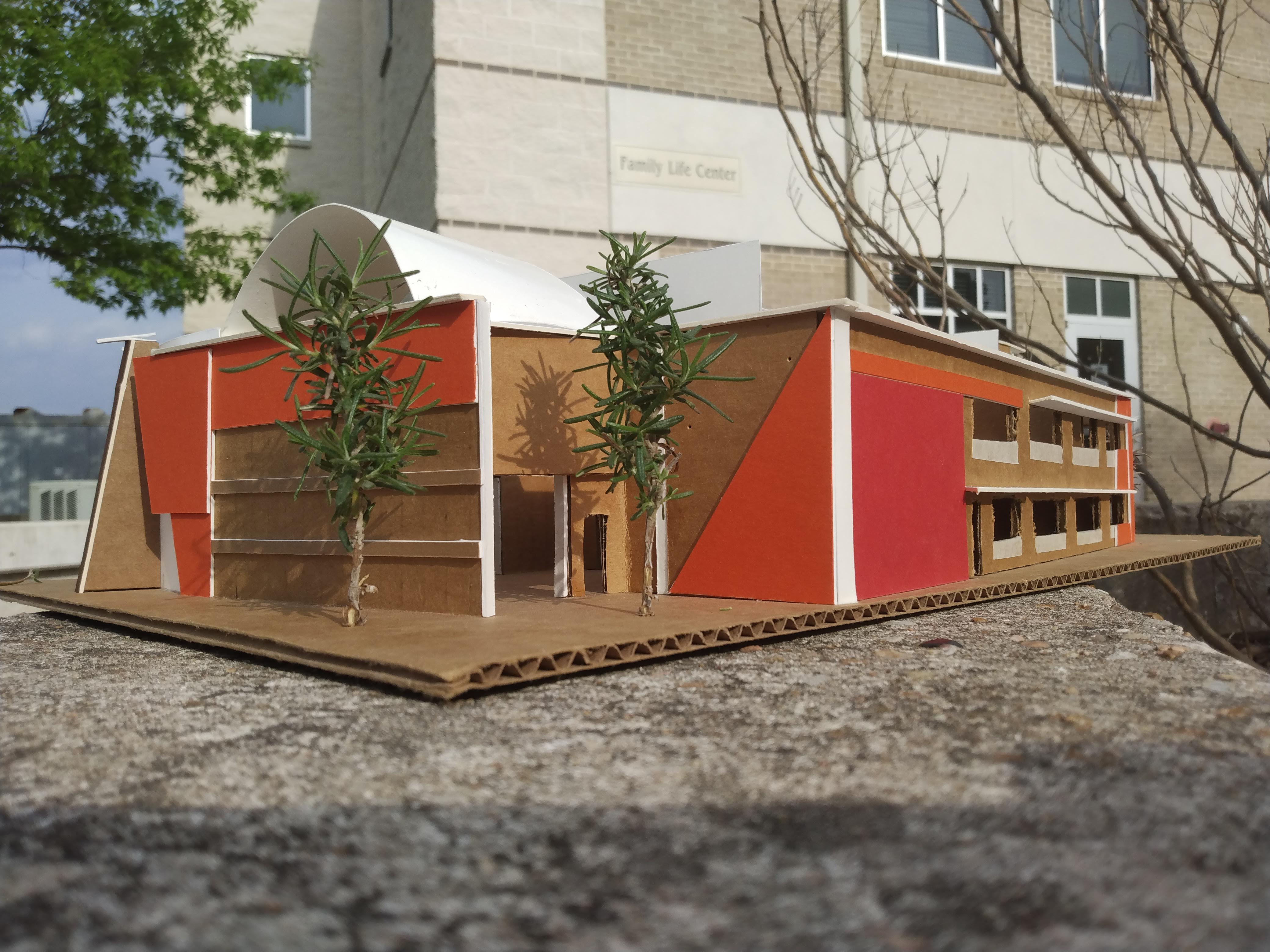 the back of the cardboard mockup is positioned in front of the imposing church building and features red-orange geometric compositional elements